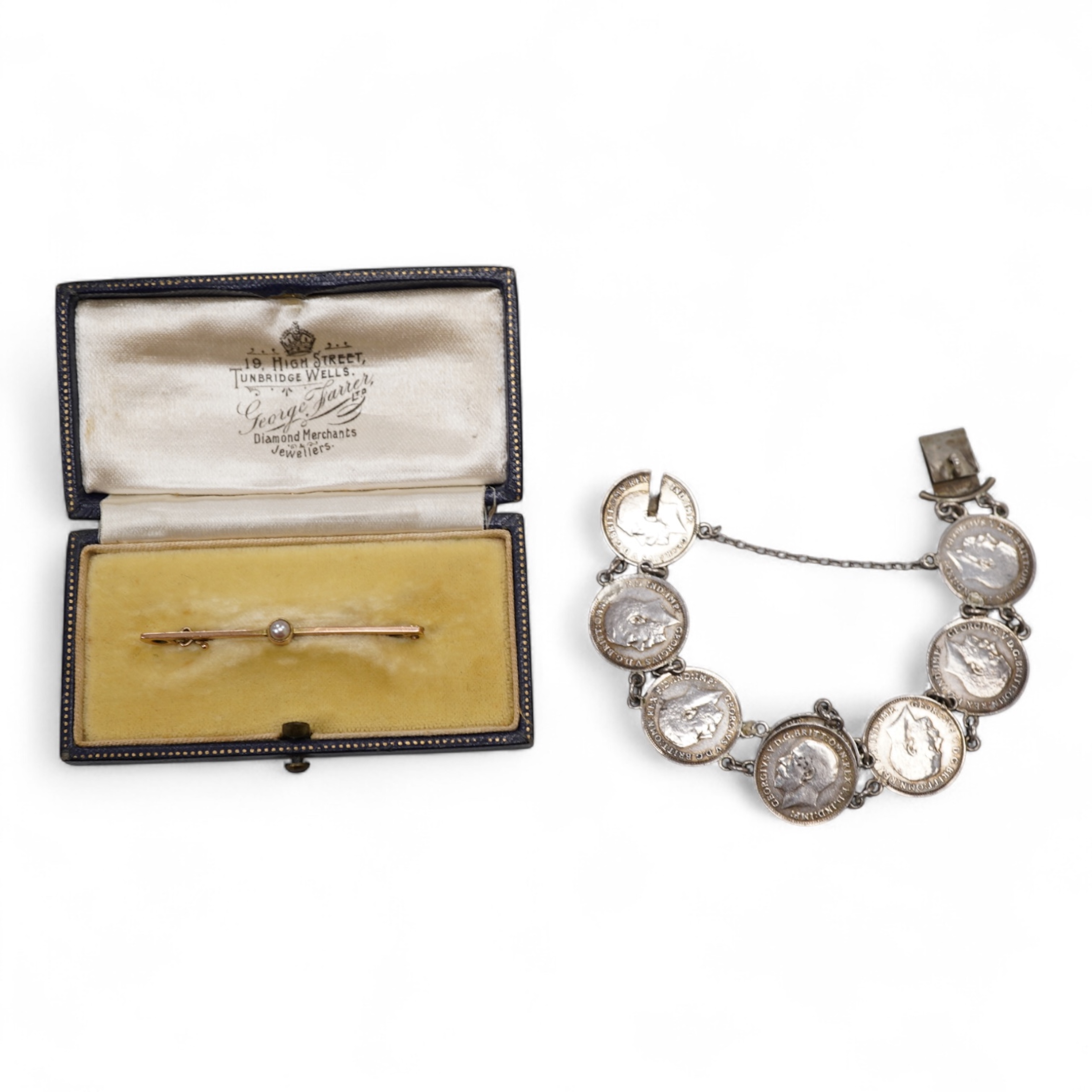 A cased early 20th century 9ct and single stone split pearl set bar brooch, 42mm and a white metal coin bracelet.